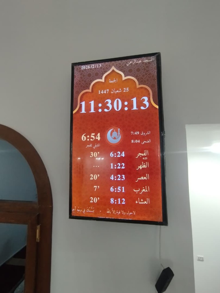 شاشة عمودية لمواقيت الصلاة على جدار أبيض
