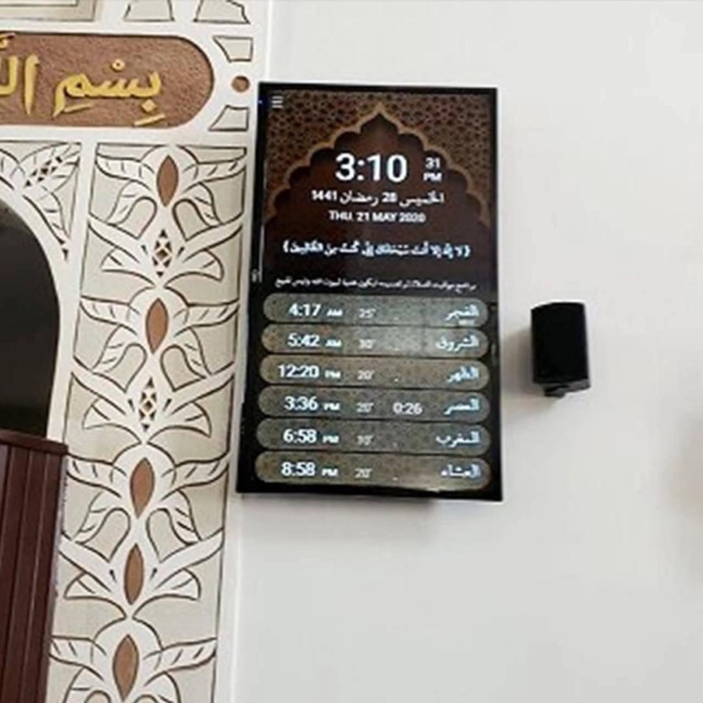 شاشة مواقيت الصلاة بجانب سماعة حائط